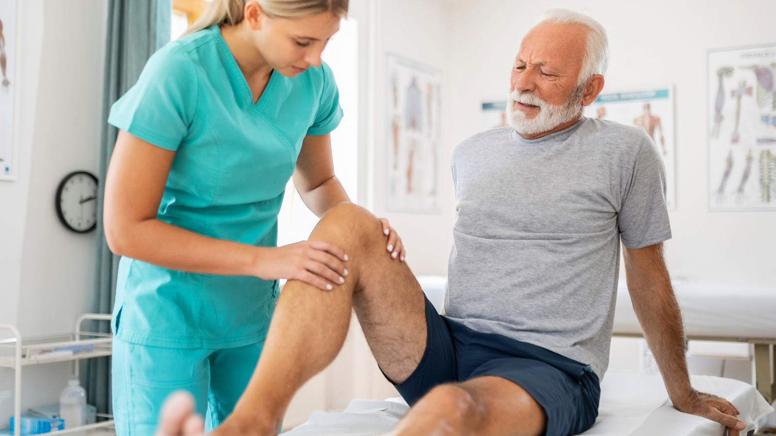Physiotherapist examining a patient's leg in a clinical setting