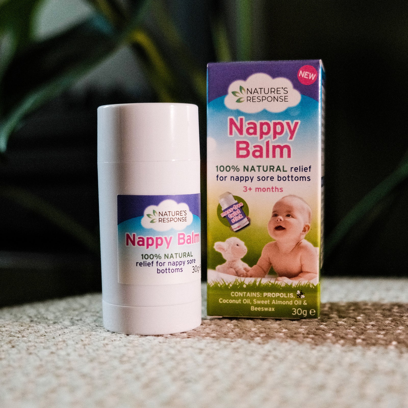 Nappy balm stick and packaging on a neutral background