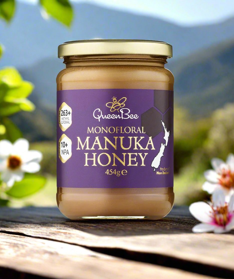 Queen Bee Manuka Honey 454g glass jar with monofloral honey label and natural outdoor background