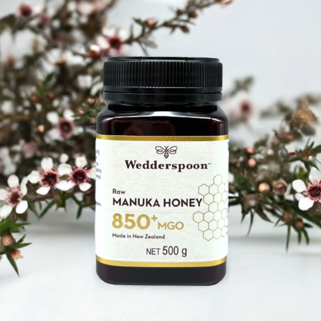 Wedderspoon raw manuka honey 850 mgo 500 gram jar with floral background