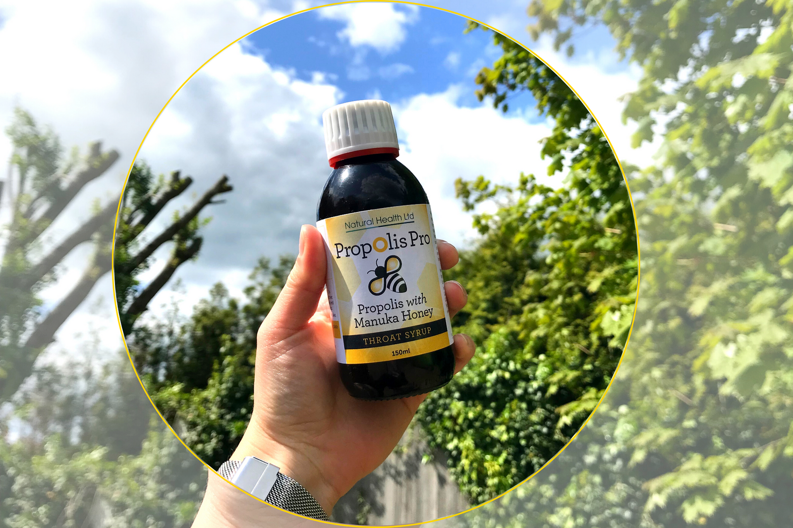 Hand holding a bottle of propolis and Manuka throat syrup benefits against a sunny outdoor background
