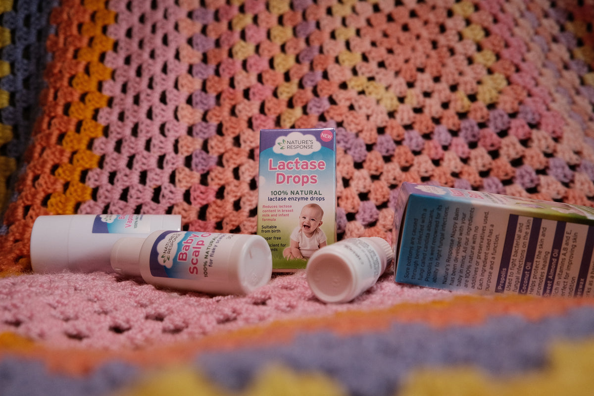 Natures Response natural lactase drops for babies bottle and packaging displayed on a pink crocheted blanket