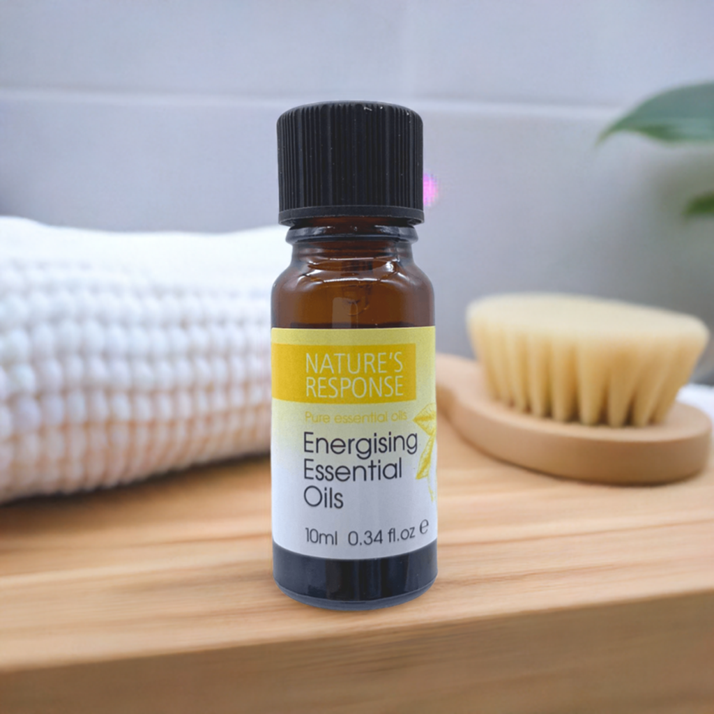 Natures Response tea tree energising essential oil 10ml amber bottle on wooden shelf with towel and brush