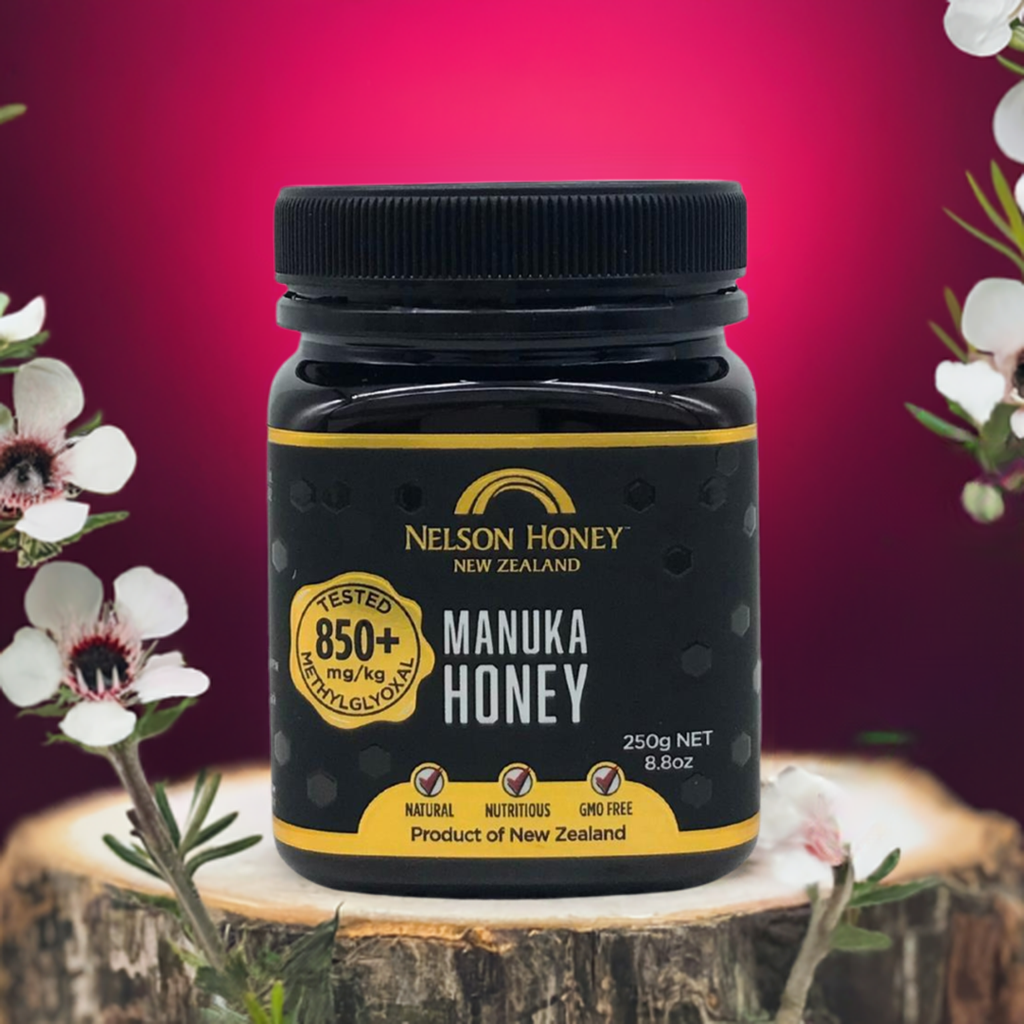 Nelson Honey Manuka honey MGO 850+ 250g jar with black label on rustic wood and manuka flowers