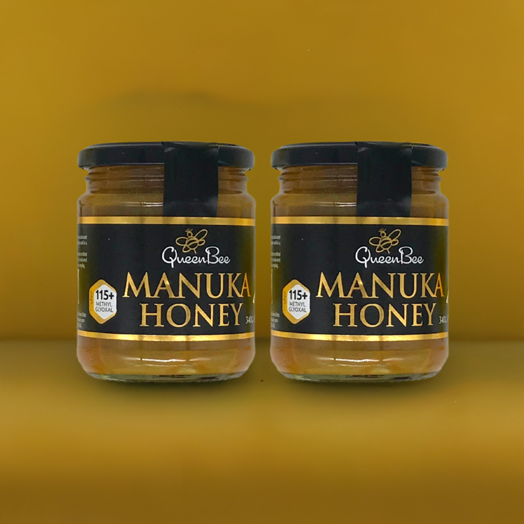 Queen Bee Manuka honey twin pack showing two glass jars with black and gold labels on yellow background