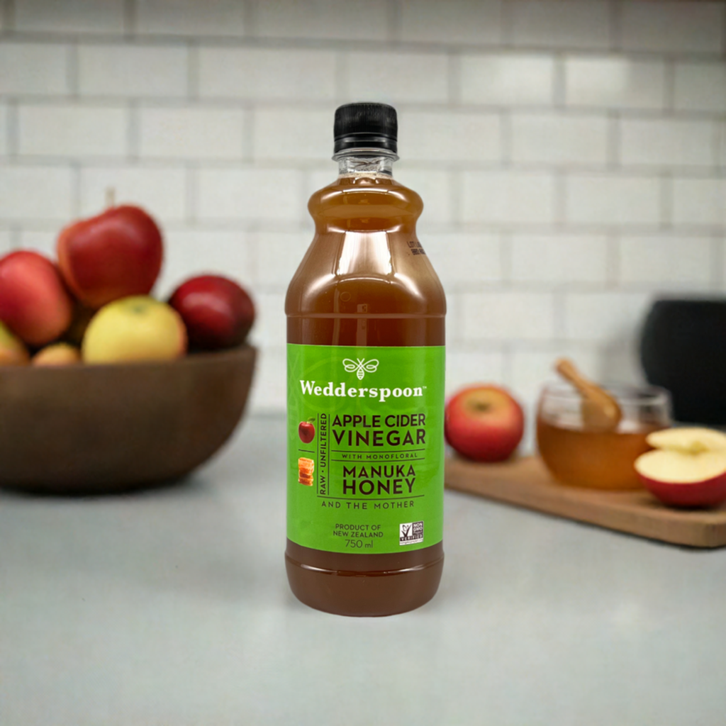 Wedderspoon Apple Cider Vinegar with Manuka Honey 750ml Triple Pack bottle on kitchen counter with apples and honey