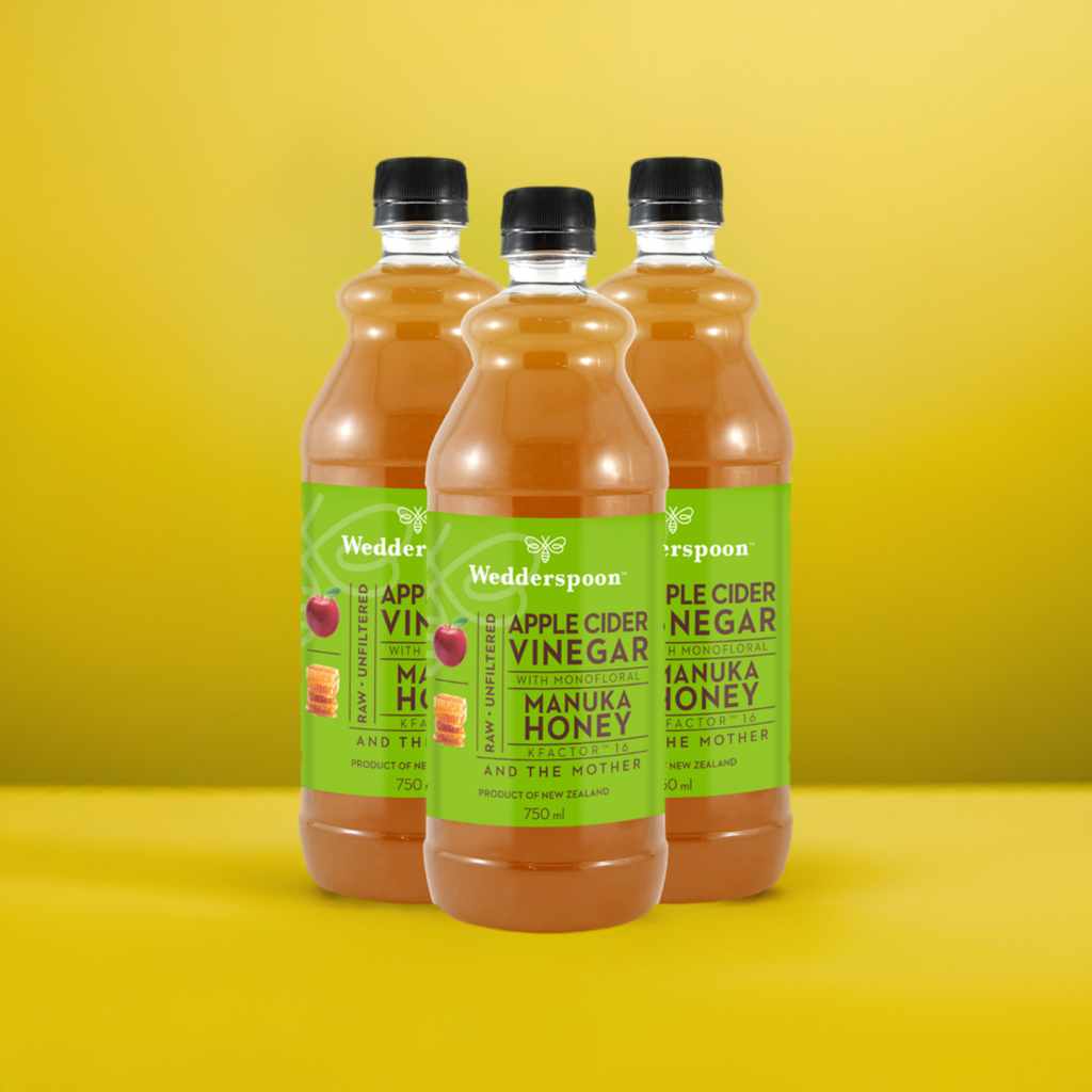 Wedderspoon Apple Cider Vinegar with Manuka Honey 750ml Triple Pack bottles on yellow background