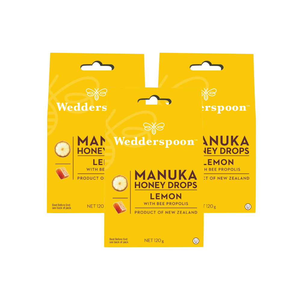 Wedderspoon packs of Manuka honey drops lemon in yellow boxes showing lemon slice and bee propolis