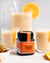 Jar of Wedderspoon raw Manuka honey KFactor 16+ with orange smoothies and honey dipper
