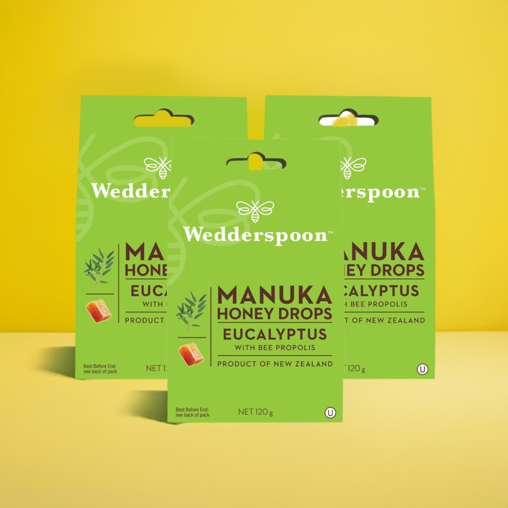 Wedderspoon Manuka honey drops eucalyptus three green boxes of eucalyptus throat lozenges on yellow background